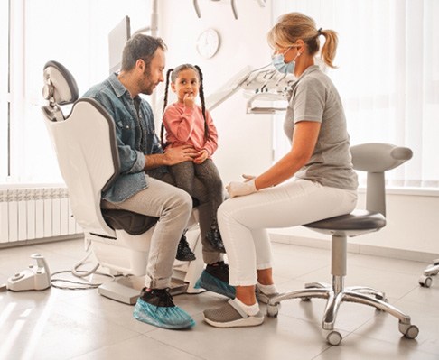 father and daughter speaking with a pediatric emergency dentist