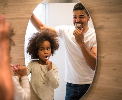 father and child brushing their teeth to avoid dental emergencies