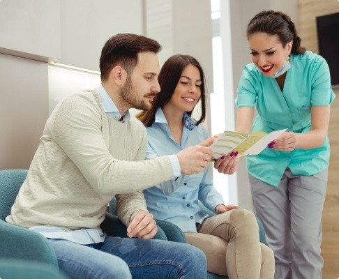 Dental team members and patients discussing how dental insurance works