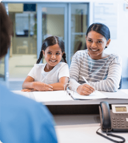 woman with her daughter at dental practice front desk
