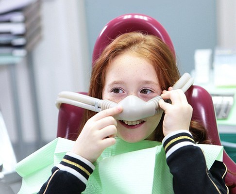 Child smiling while holding nasal mask