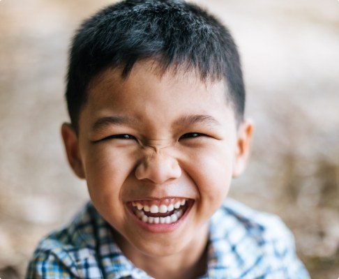 Child with healthy smile after dental checkups and teeth cleanings