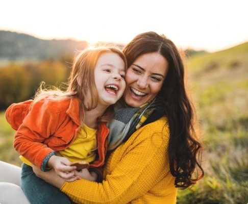 Mother hugging child after dental sealant visit