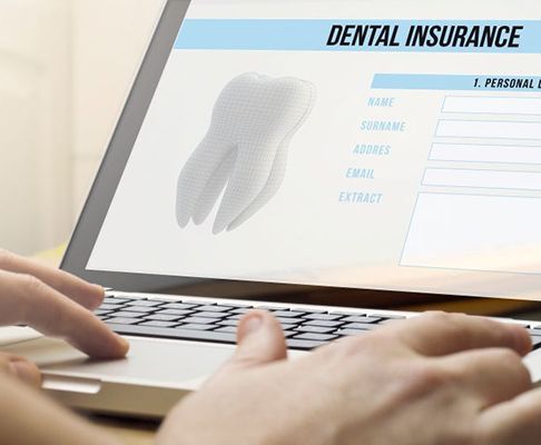 Person filling out dental insurance form on laptop