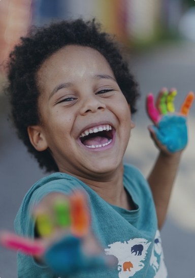 Child sharing healthy smile after preventive dentistry visit