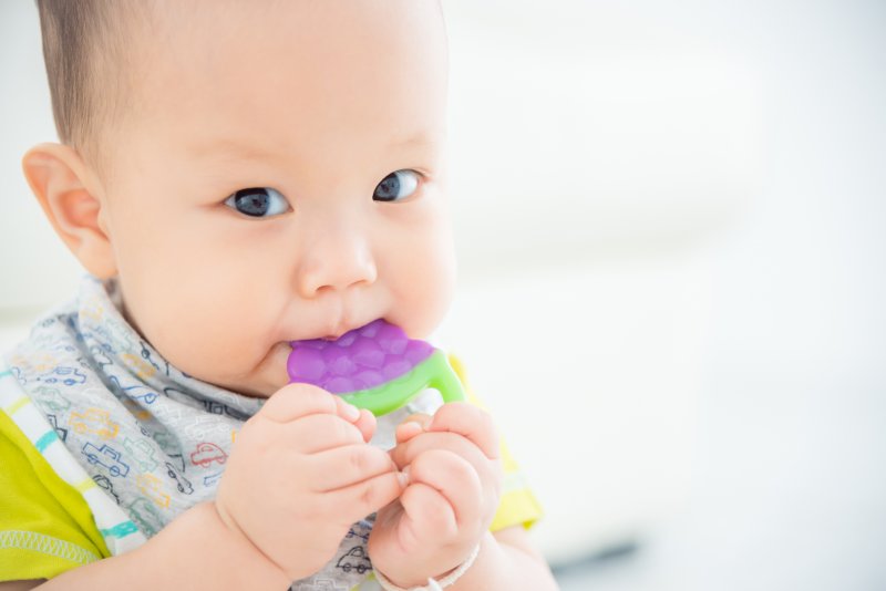 Baby teething on a cold toy