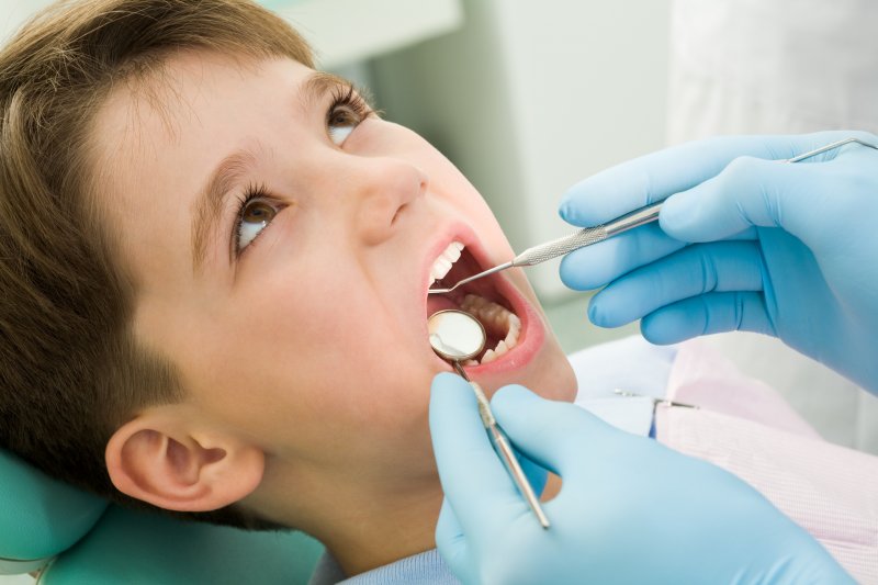 little boy having his mouth checked