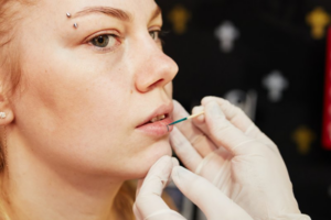 Piercer preparing to give a client a lip piercing 