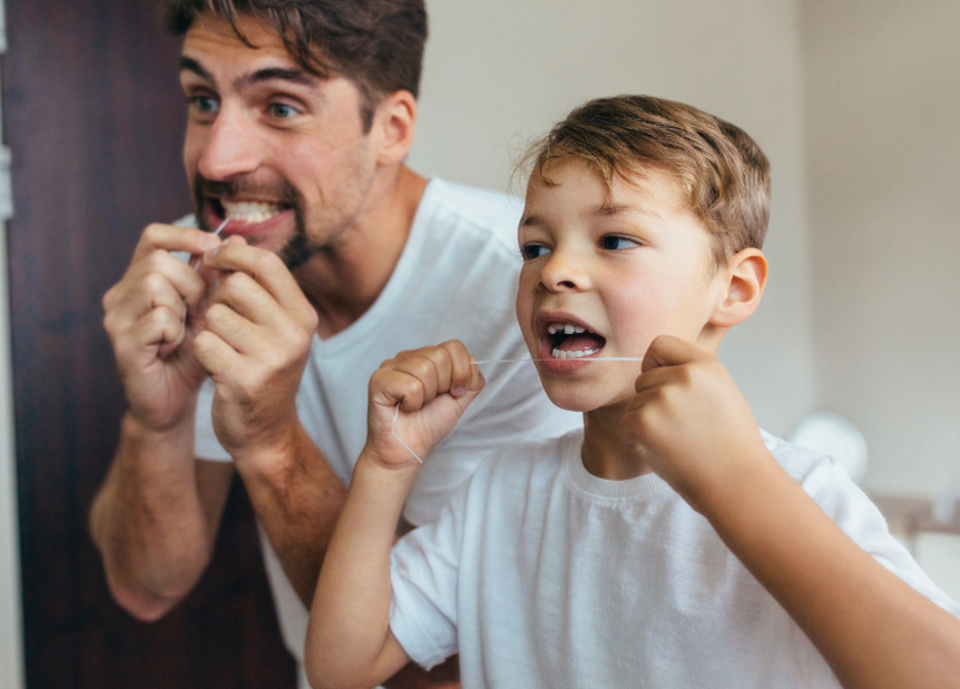 Father and young son flossing
